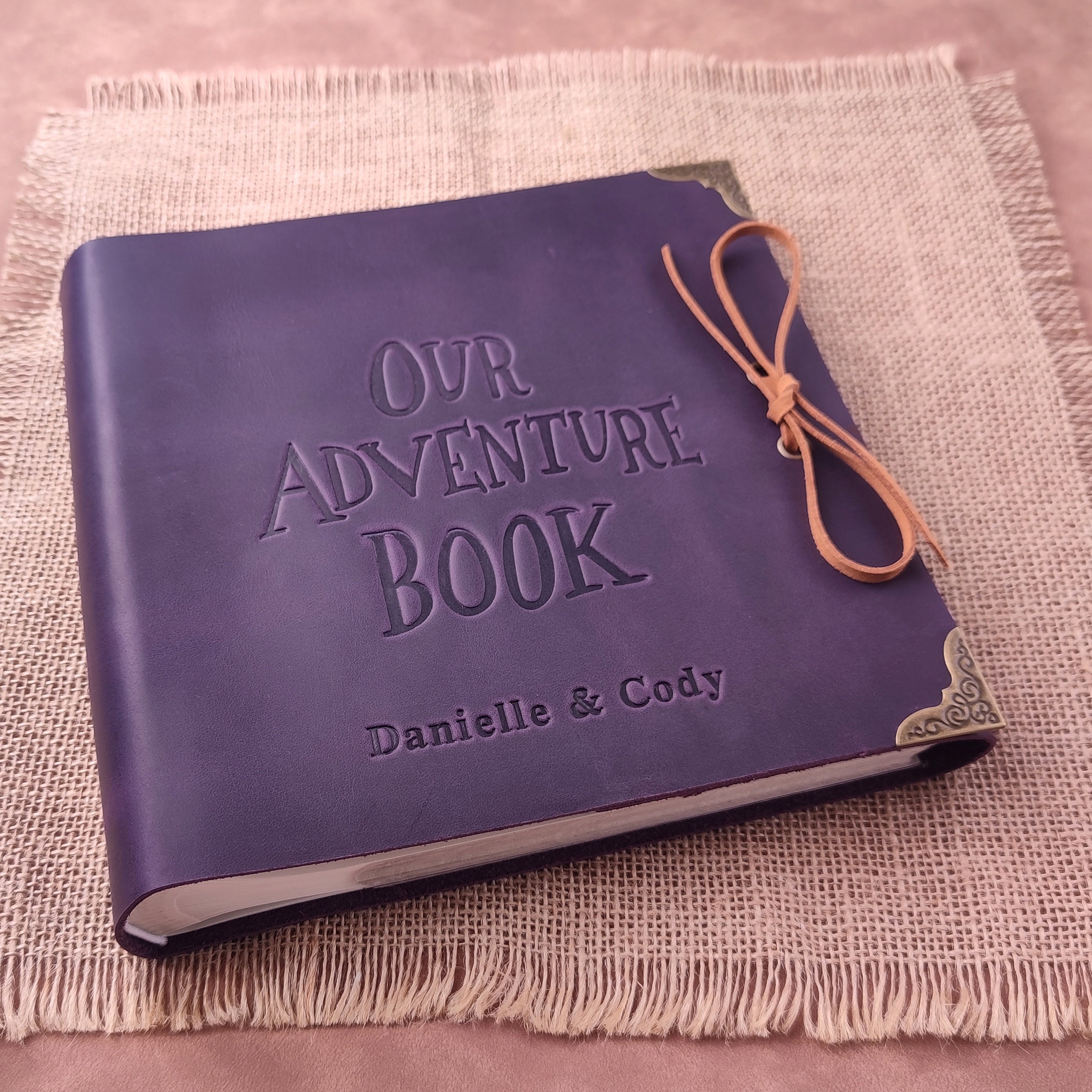 Beautiful purple scrapbook titled Our Adventure Book, perfect anniversary gift for couples.
